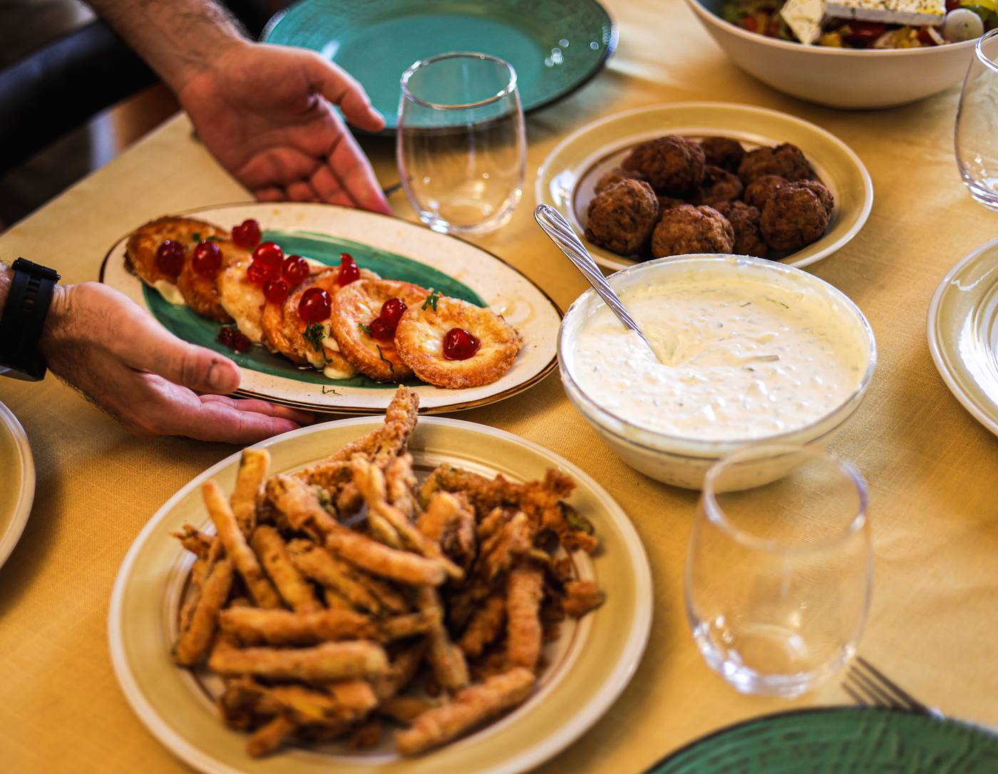 A full table spread of Greek dishes shared at the end of a class
